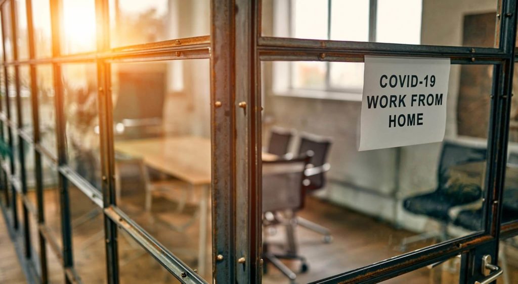 Picture of an empty office with a Covid-19 work from home sign outside